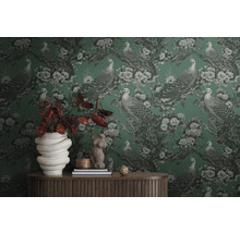 Pièce avec papier peint à motifs de paons et de fleurs, décorée d''accessoires pour la maison sur une table en bois