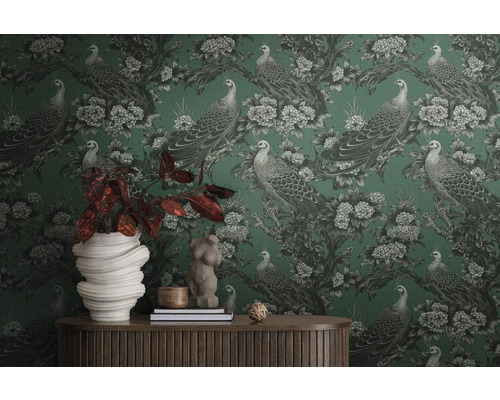 Pièce avec papier peint à motifs de paons et de fleurs, décorée d''accessoires pour la maison sur une table en bois