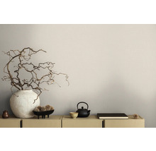 Scène décorative avec vase, branches, théière et bol sur un buffet