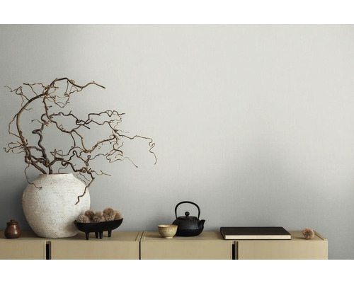 Branches décoratives dans un vase, théière et bol sur un buffet