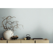 Branches décoratives dans un vase à côté d''une théière sur un buffet