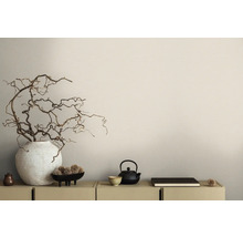 Arrangement décoratif avec vase, branches, théière et livre sur une armoire
