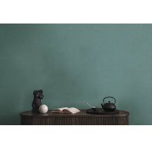 Gros plan d''un papier peint structuré vert au-dessus d''une table avec des décorations.