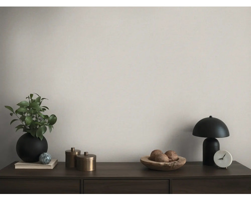 Arrangement décoratif avec lampe de table, plante et accessoires sur un buffet