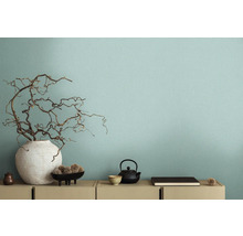 Intérieur décoratif avec vase et branches devant un mur