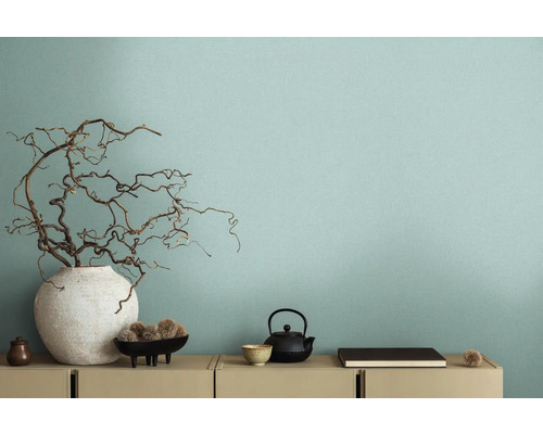 Intérieur décoratif avec vase et branches devant un mur