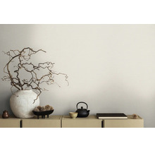 Scène décorative avec vase, branches, théière et bol sur une armoire