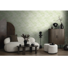Salon avec papier peint à motifs, canapé, tabouret et meubles en bois foncé.