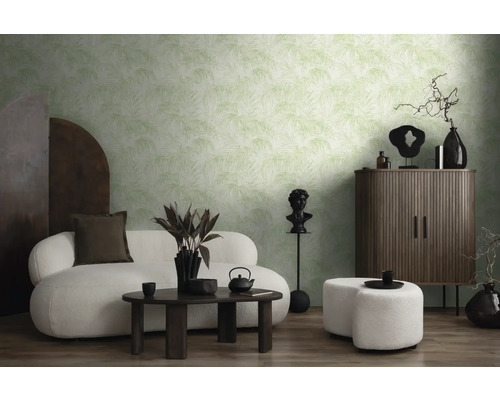 Salon avec papier peint à motifs, canapé, tabouret et meubles en bois foncé.