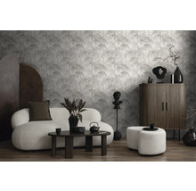 Salon avec canapé, table basse, armoire et papier peint à motif de feuilles de palmier pour un intérieur moderne.