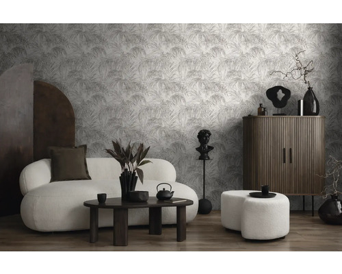 Salon avec canapé, table basse, armoire et papier peint à motif de feuilles de palmier pour un intérieur moderne.