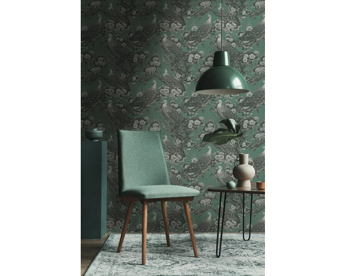 Exemple d''aménagement intérieur avec un papier peint vert à motif d''oiseaux, une chaise verte et une lampe assortie