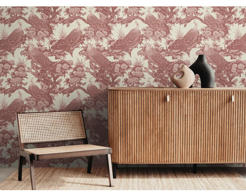 Papier peint décoratif avec motif de paon derrière une commode et une chaise