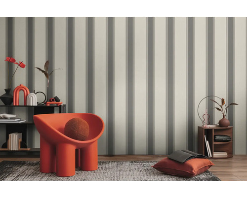 Espace aménagé avec papier peint à rayures, fauteuil et éléments décoratifs