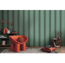 Salon mis en scène avec papier peint à motifs, fauteuil, tapis et table d''appoint.