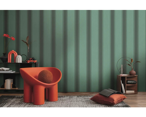 Salon mis en scène avec papier peint à motifs, fauteuil, tapis et table d''appoint.