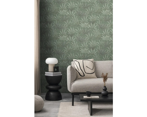 Salon avec canapé, table et papier peint vert à motifs de feuilles