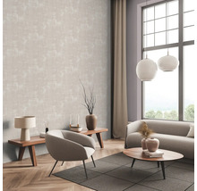 Wohnzimmer mit gemusterter Tapete, Sofa, Sessel und Holztischen.