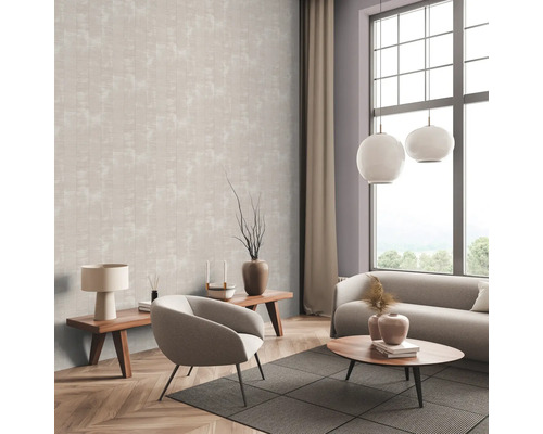 Salon avec papier peint à motifs, canapé, fauteuil et tables en bois.