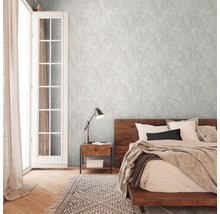 Chambre avec lit double, table de chevet, lampe et papier peint à motifs