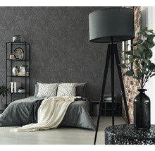 Chambre avec lit, étagère, lampadaire et papier peint à motifs