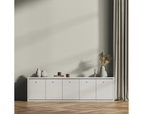 Scène de salon avec buffet blanc, décoration et rideau sur parquet.