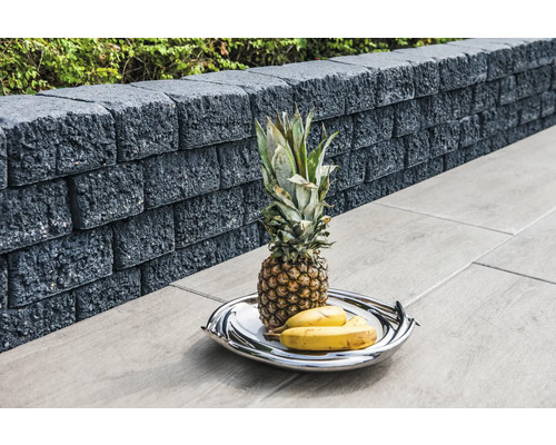 Muret de jardin en pierres de béton avec ananas et bananes sur un plateau de service