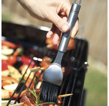 Person bestreicht Grillgut mit einem Pinsel von OXO