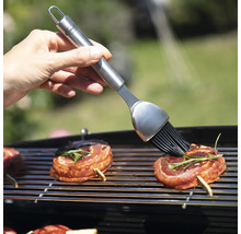 Grillpinsel mit Grillgut auf Grillrost