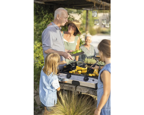 Plusieurs personnes font griller des aliments en plein air avec un gril Eno.