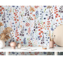 Scène avec papier peint floral, bureau, décorations et papeterie.