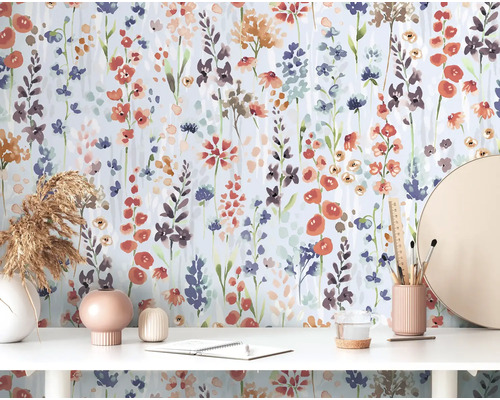 Scène avec papier peint floral, bureau, décorations et papeterie.