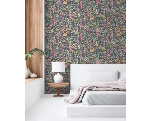 Chambre avec papier peint à motifs floraux, lit et table de chevet avec lampe