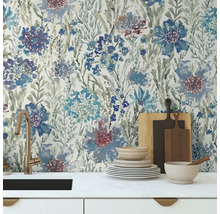 Scène de cuisine avec papier peint floral, évier, vaisselle et planches à découper.