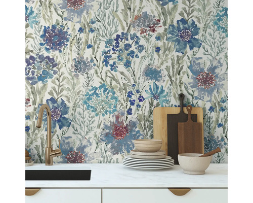 Scène de cuisine avec papier peint floral, évier, vaisselle et planches à découper.