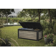 Gartenszene mit einer geöffneten Gartenbox zur Aufbewahrung von Kissen und Decken