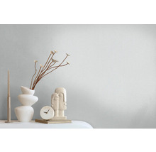 Dekorative Stilllebenanordnung mit Kerze, Vase, Dekoration, Uhr und Figuren.