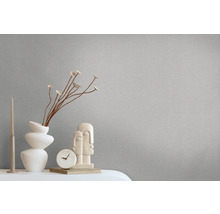 Nahaufnahme einer grauen Tapete mit Dekorationselementen wie einer Vase, einer Skulptur und einer Uhr