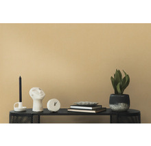 Dekorative Szene mit Kerze, Skulptur, Uhr, Büchern und Zimmerpflanze auf einem schwarzen Tisch