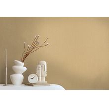 Dekorative Szene mit einer Vase, Zweigen, einer Kerze, einer Uhr und einer Skulptur auf einem Tisch.