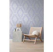 Dekorative Tapete mit Ornamentmuster im Wohnraum mit Lampe und Sessel