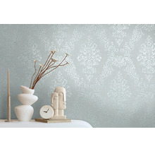 Dekoratives Zimmer mit Ornamenttapete, Vase, Skulptur, Kerze und Uhr