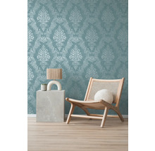 Dekoratives Zimmer mit Ornamenttapete, Sessel aus Holz und Beistelltisch