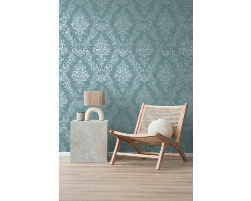 Dekoratives Zimmer mit Ornamenttapete, Sessel aus Holz und Beistelltisch