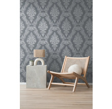 Raumansicht mit gemusterter Tapete, Sessel und Beistelltisch