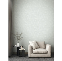 Wohnzimmer mit gemusterter Tapete, Sessel und Beistelltischen