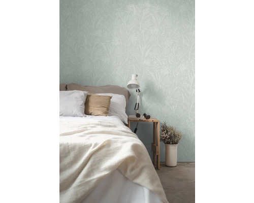 Schlafzimmer mit Bett und floral gemusterter Tapete