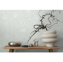 Dekoratives Stillleben mit Blumentapete im Hintergrund, arrangiert auf einem Holztisch.