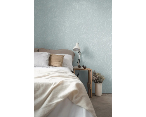 Schlafzimmer mit floral gemusterter Tapete, Bett und Nachttischlampe