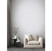 Wohnzimmer mit gemusterter Tapete, Sessel und Beistelltischen